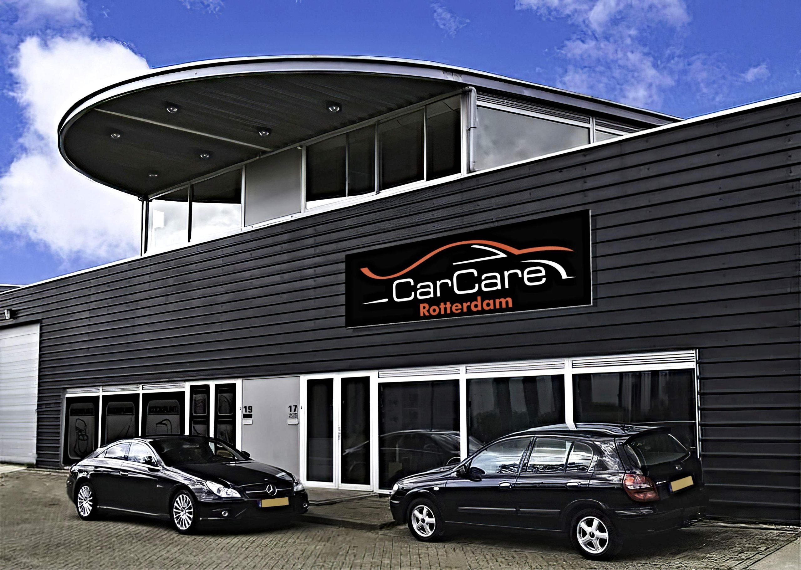 Het pand van Car Care Rotterdam met de ronde dakoverkapping en twee auto's ervoor